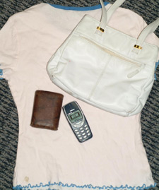 Imagen de una pila de cosas con bolso, camisa, telfono