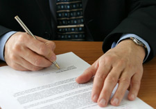 Image of a man signing a form.